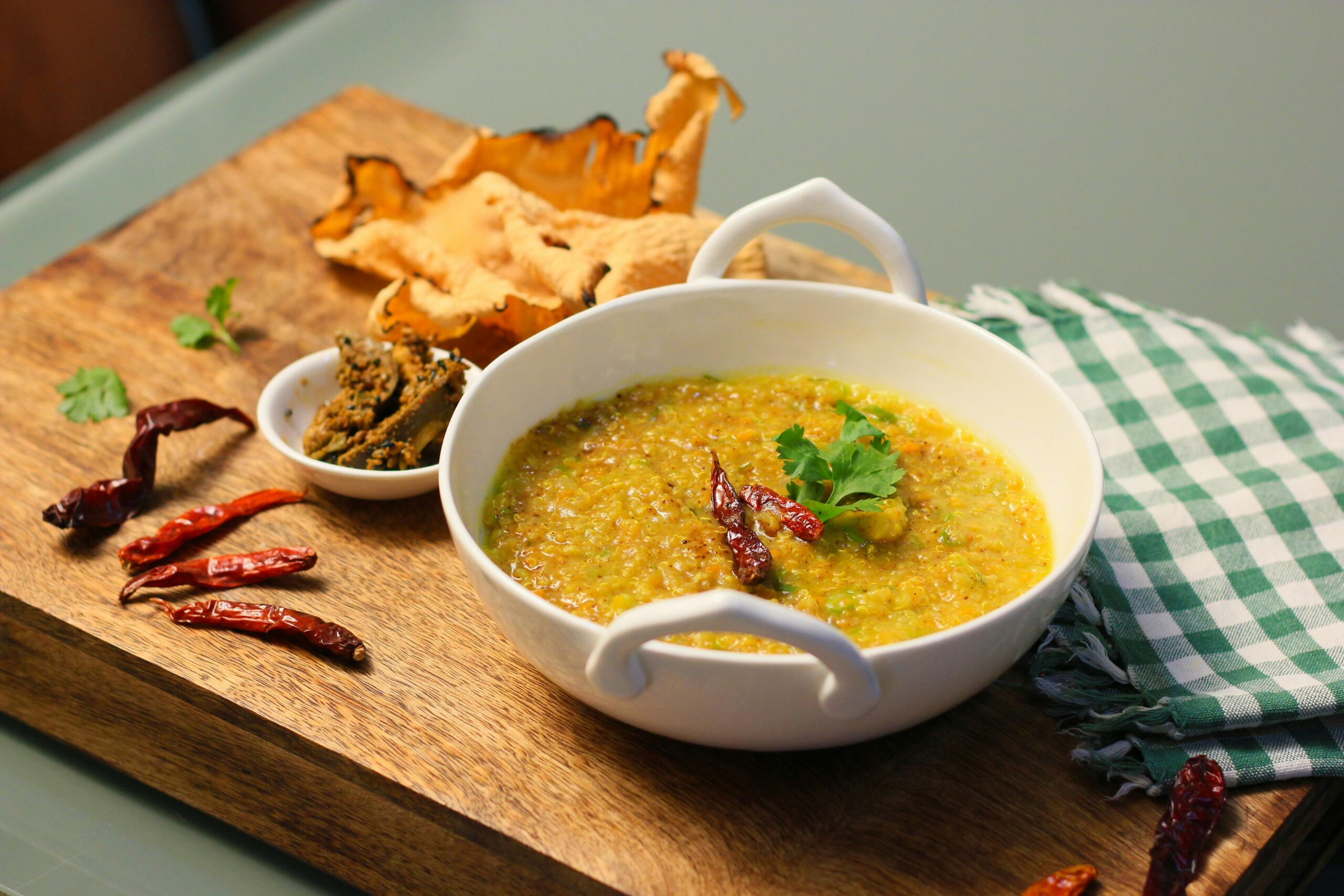 A vibrant Indian khichdi dish served with chilies and papad, perfect for a spicy meal.